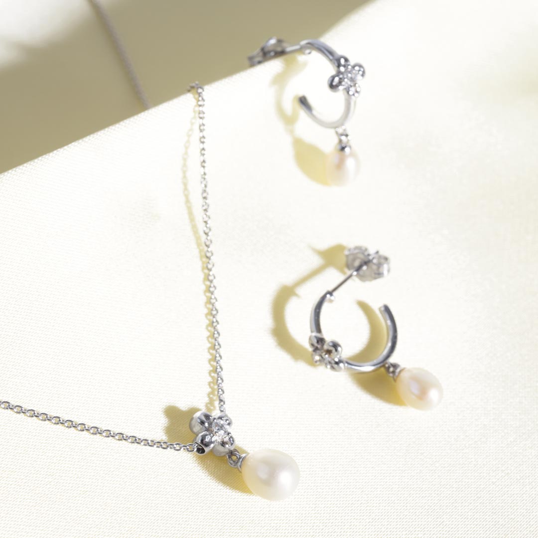 Silver necklace with pearls on a white background