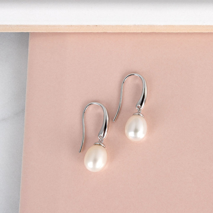 Pearl earrings on a pink background