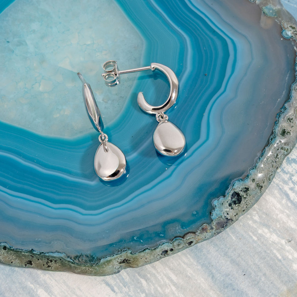 Silver earrings on a blue and gray agate stone
