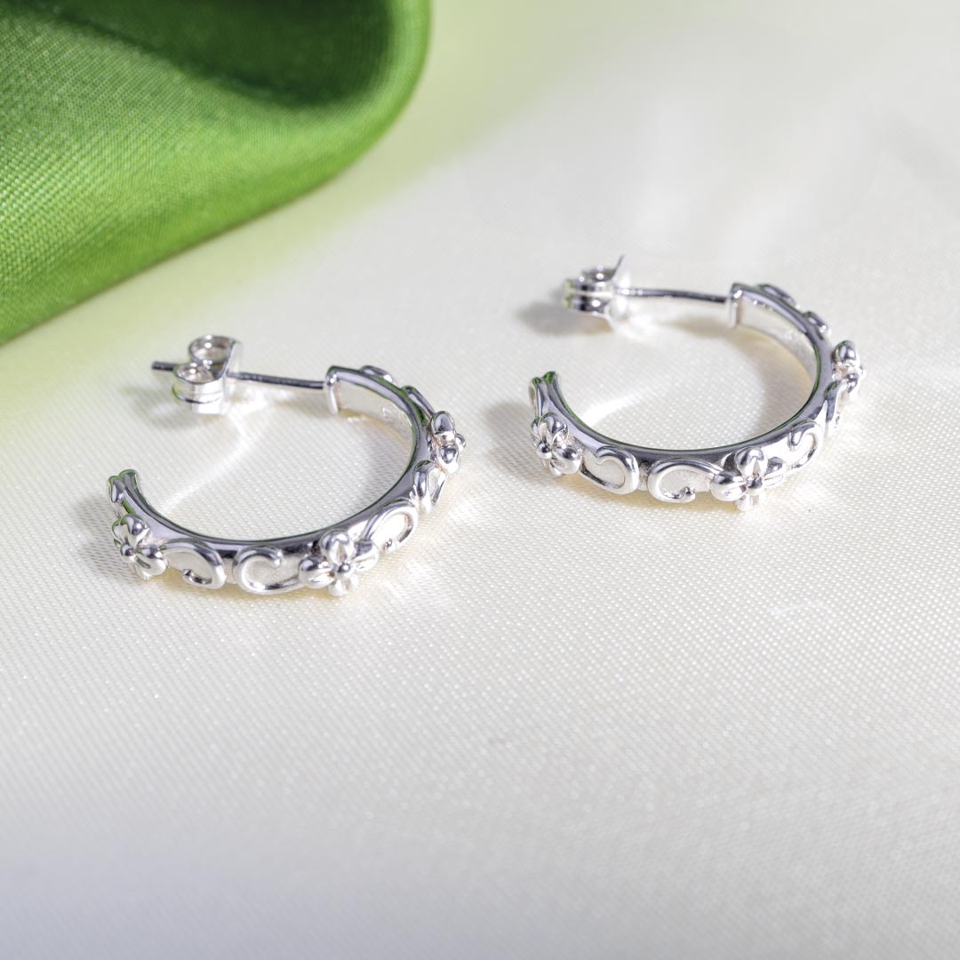 Silver hoop earrings on a light gray background