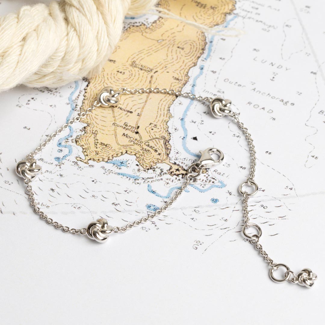 Silver bracelet on a map with yarn