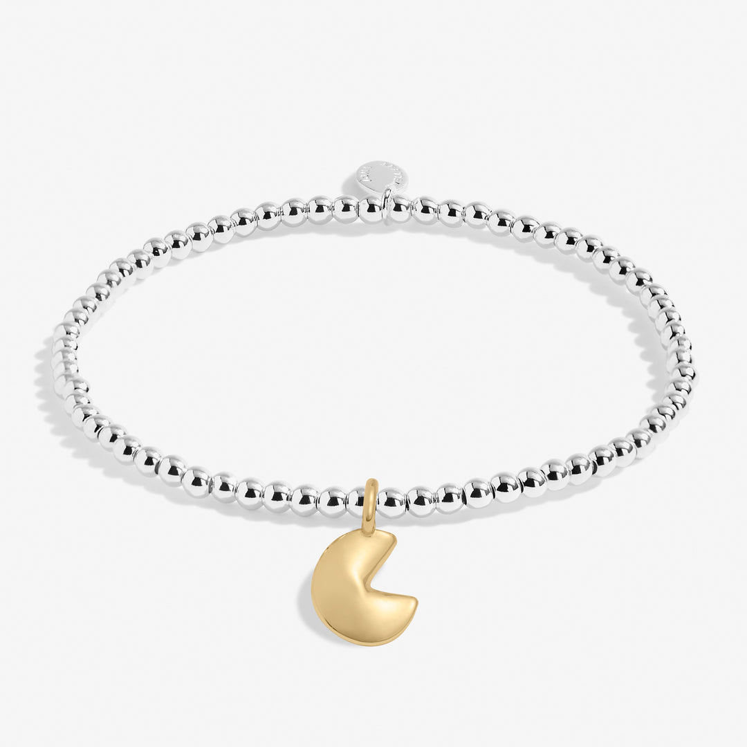 a silver bracelet with a gold heart charm