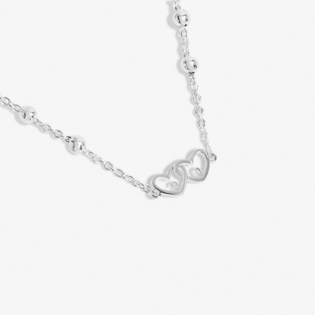 a necklace with two hearts hanging from it