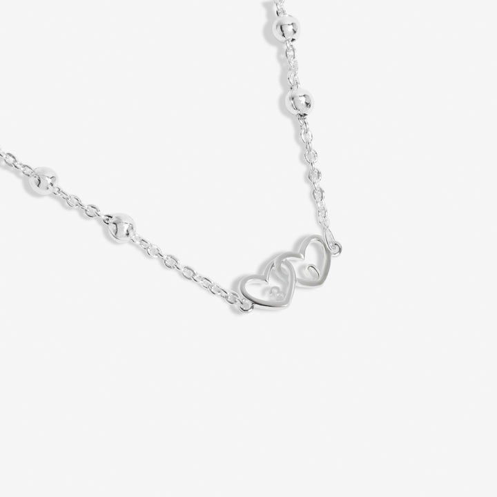 a necklace with two hearts hanging from it