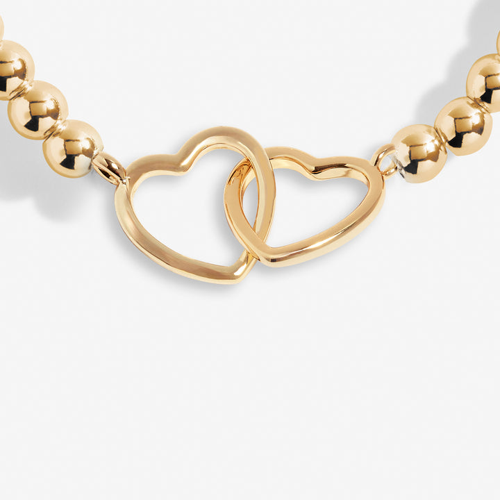 a gold necklace with two hearts on it