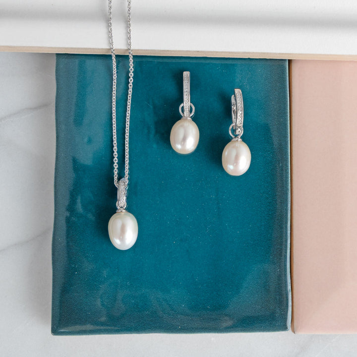 Pearl necklace and earrings on a teal jewelry box
