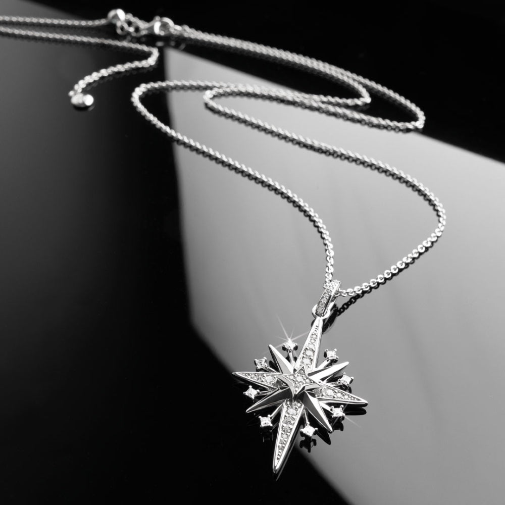 Silver star-shaped pendant necklace on a dark background