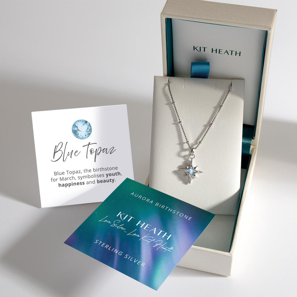 Kit Heath silver necklace with blue topaz star pendant in a box, accompanied by information cards.