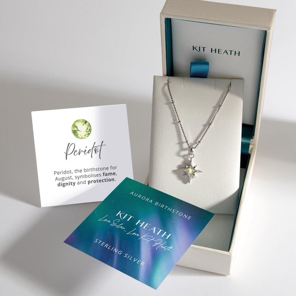 Kit Heath necklace with star pendant and peridot stone in a box with branded card