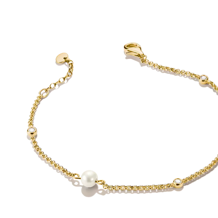 A delicate gold chain bracelet featuring a central white pearl bead and small bezel-set clear stones, displayed on a clean white background.