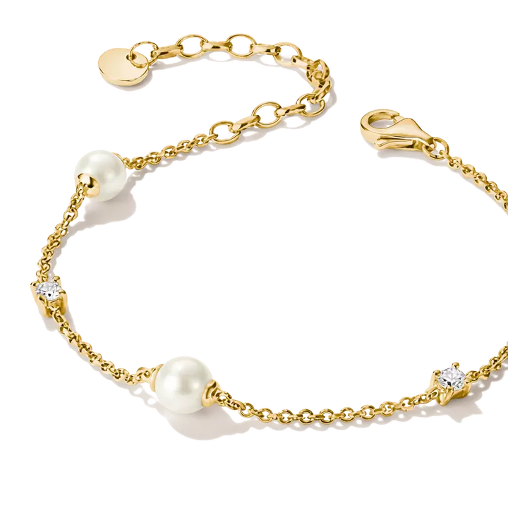 A delicate gold chain bracelet featuring three white pearl beads and two small star-shaped settings with clear stones, displayed on a clean white background.