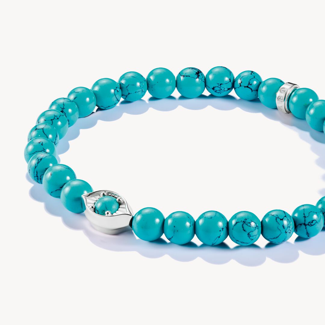 Turquoise beaded bracelet with a silver clasp on a white background