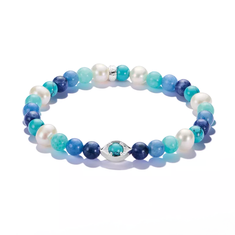 A beaded stretch bracelet featuring a mix of white pearls, light and dark blue beads, and turquoise-blue marbled beads, accented by a silver-tone evil eye charm with a turquoise center, shown on a clean white background.