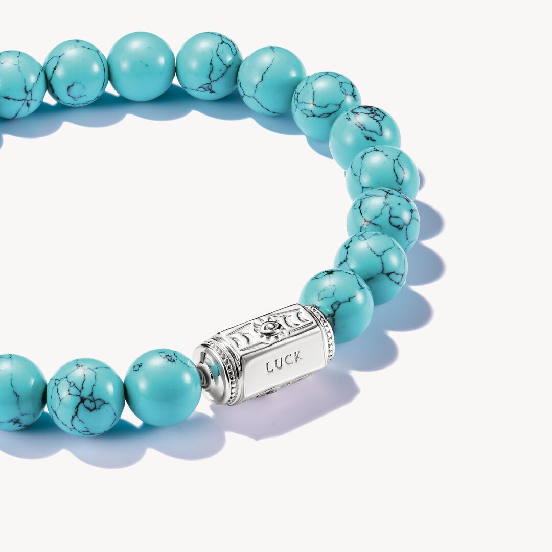 Turquoise beaded bracelet with a silver clasp on a white background