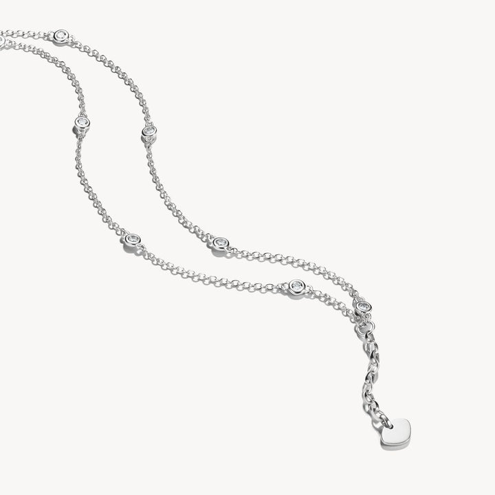 Silver necklace with small round pendants on a white background