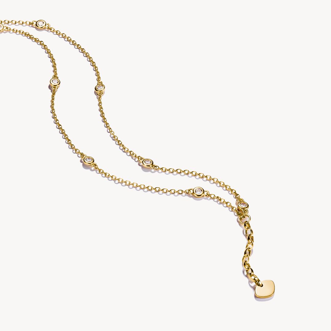 Gold bracelet with small heart charms on a white background