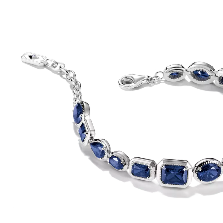 A silver-toned bracelet featuring alternating marquise and square-cut deep blue gemstones in bezel settings, shown on a clean white background.