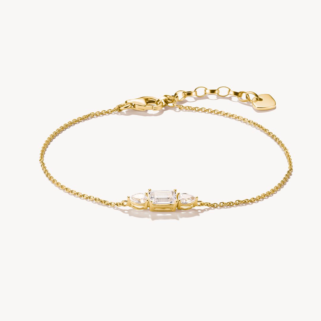 Gold bracelet with clear gemstones on a white background