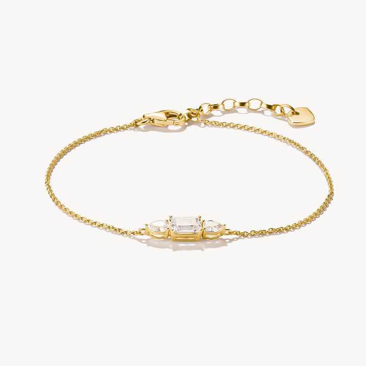 Gold bracelet with clear gemstones on a white background