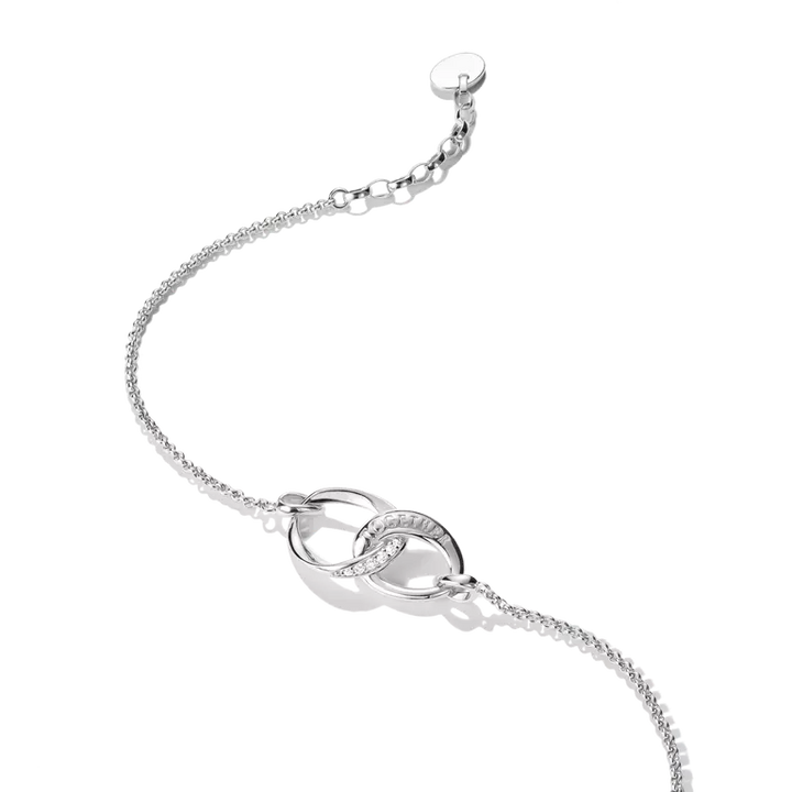 A silver chain bracelet featuring two interlocking oval links, one of which is set with small clear stones, shown on a clean white background.