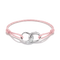 A delicate pink cord bracelet featuring a polished silver infinity symbol centerpiece with a small pavé diamond accent and the engraved word 'LOVE'.