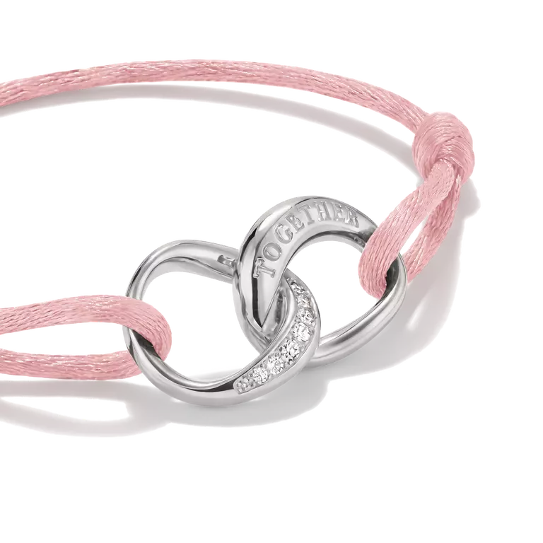 A silver-toned double-ring charm bracelet with a pink woven cord and small clear stones, featuring the engraved word 'TOGETHER' on one ring, shown on a white background.