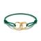 A green cord bracelet with a gold infinity-style link centerpiece featuring a row of small clear stones and the brand name 'Chanel' engraved on one side, shown on a white background.
