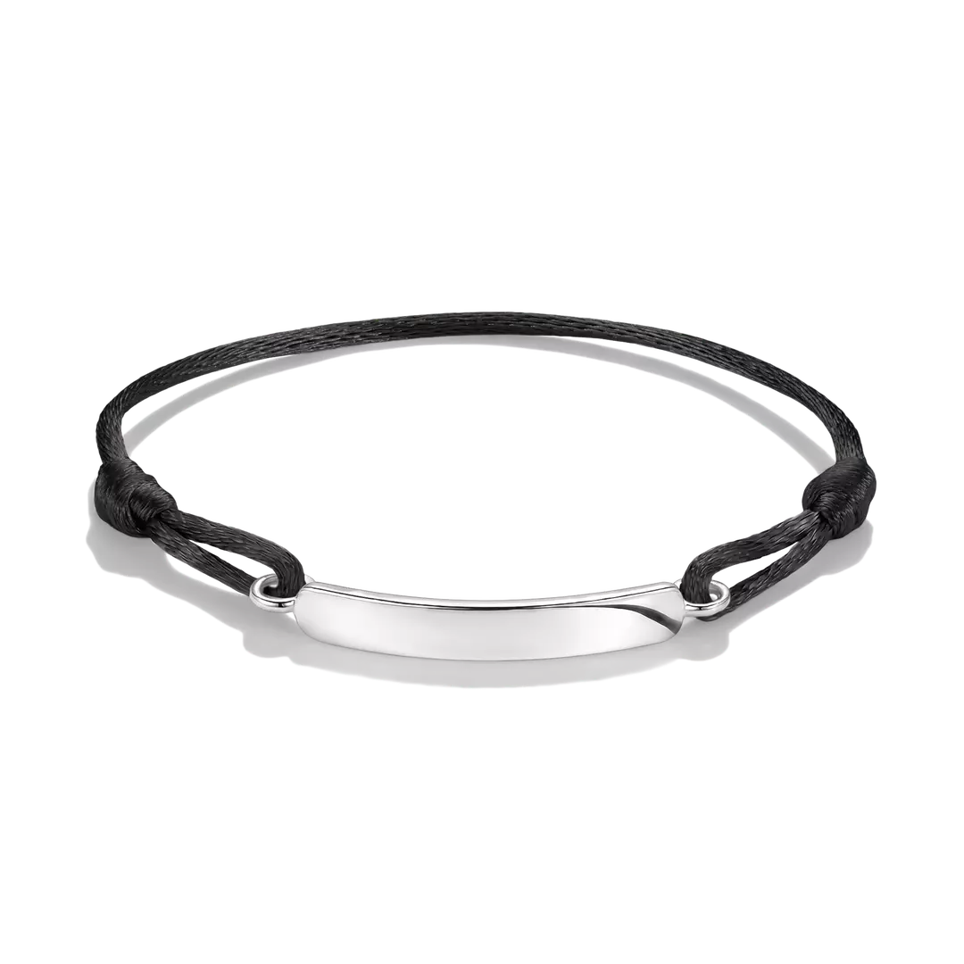 A minimalist black cord bracelet with a polished silver-tone oval plate in the center, displayed on a clean white background.
