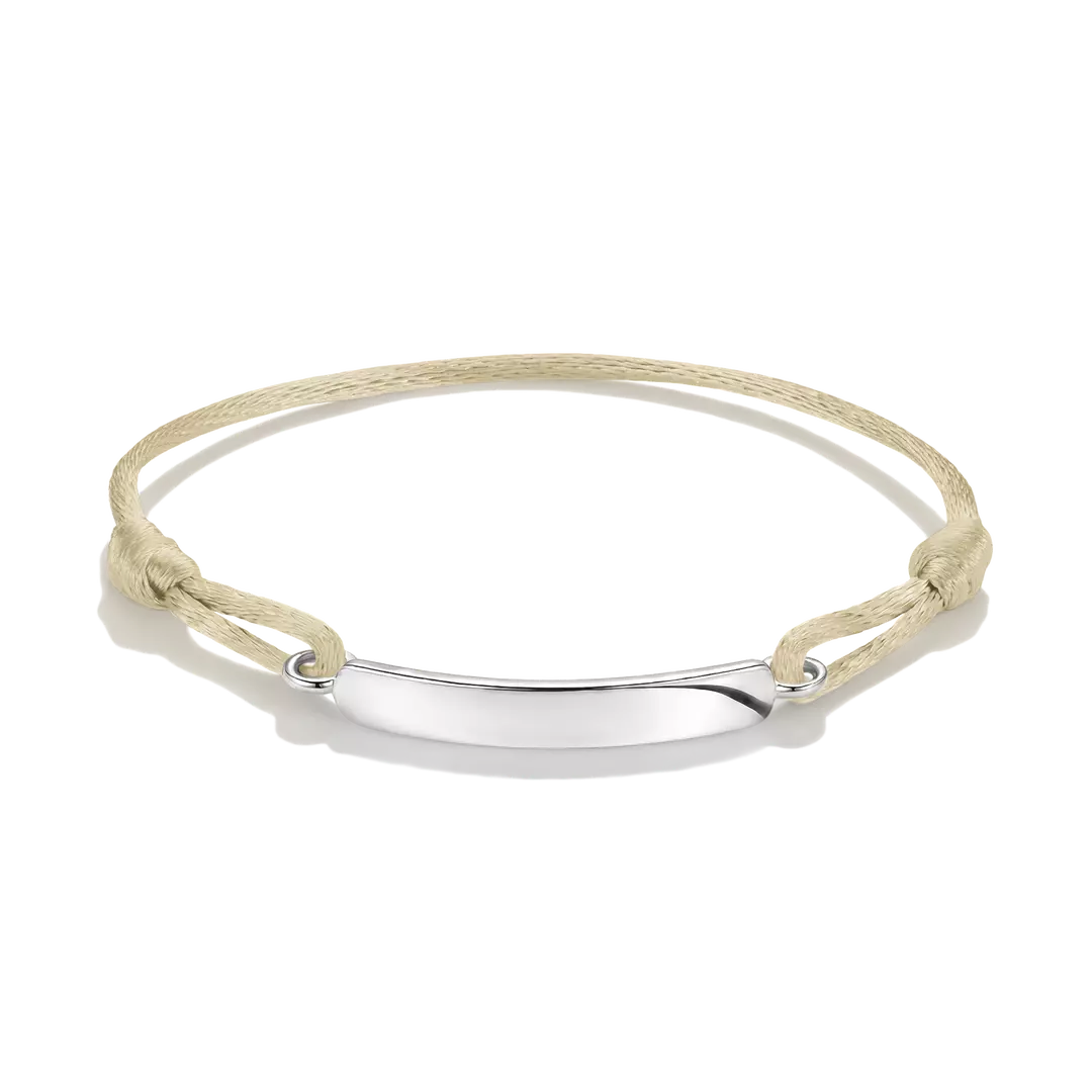 A minimalist ID bracelet featuring a polished silver-tone horizontal bar suspended on a knotted beige cord, shown against a clean white background.