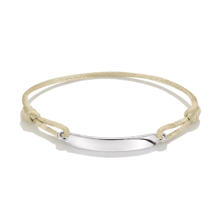 A minimalist ID bracelet featuring a polished silver-tone horizontal bar suspended on a knotted beige cord, shown against a clean white background.