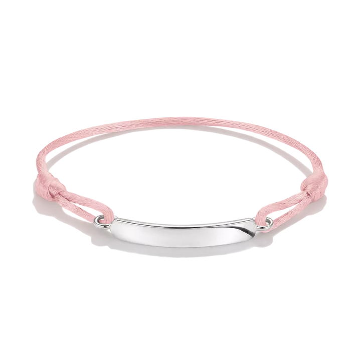 A delicate pink cord bracelet with a polished silver-tone oval plate in the center, displayed on a clean white background.
