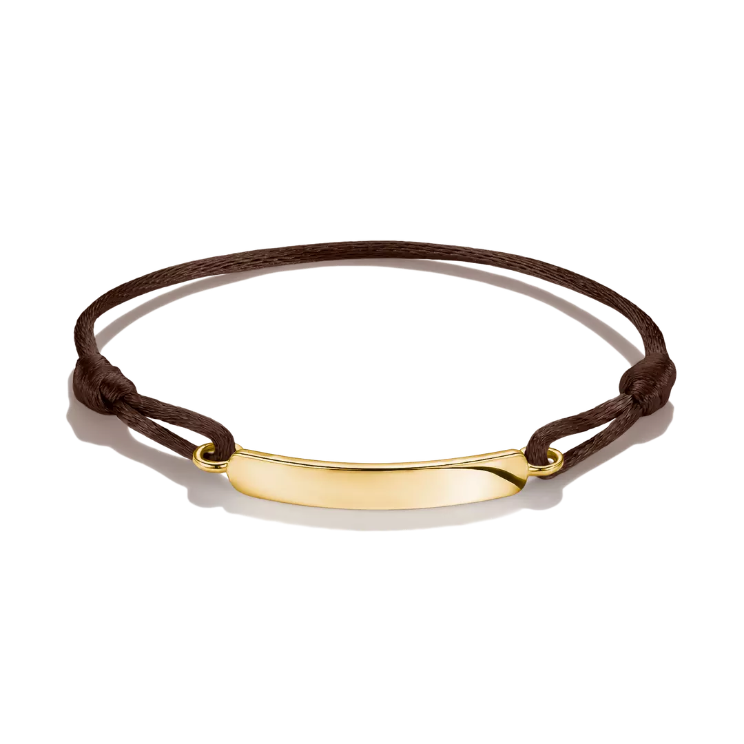 A dark brown cord bracelet with a polished gold-tone curved bar pendant, displayed on a clean white background.