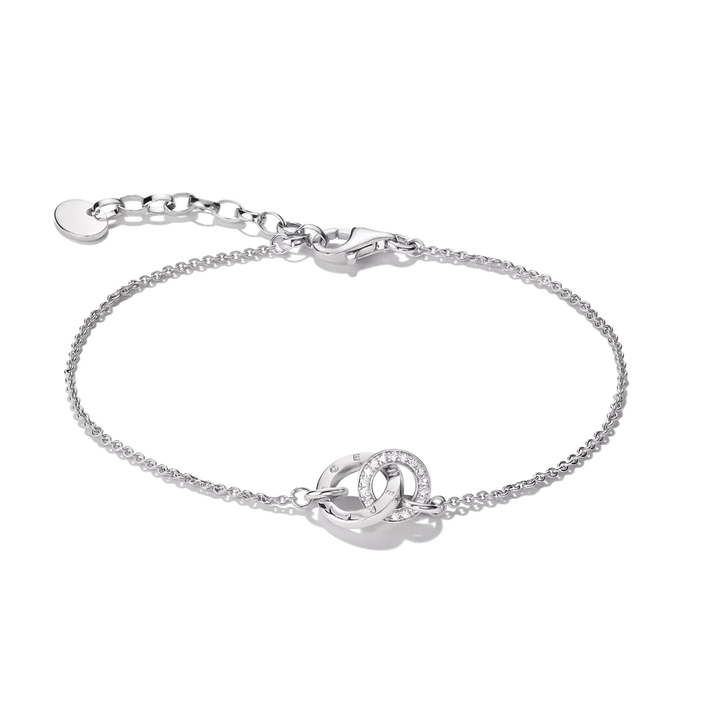 A silver chain bracelet with a central interlocking double-ring motif, one of which is set with small clear stones, shown on a plain white background.