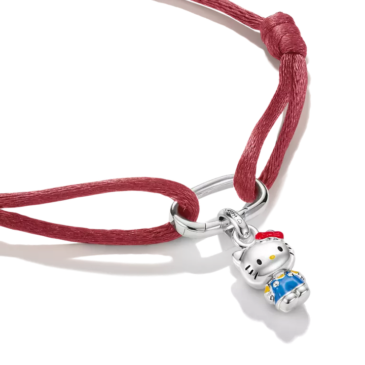 A sterling silver Hello Kitty charm pendant on a red adjustable cord bracelet, shown on a clean white background.