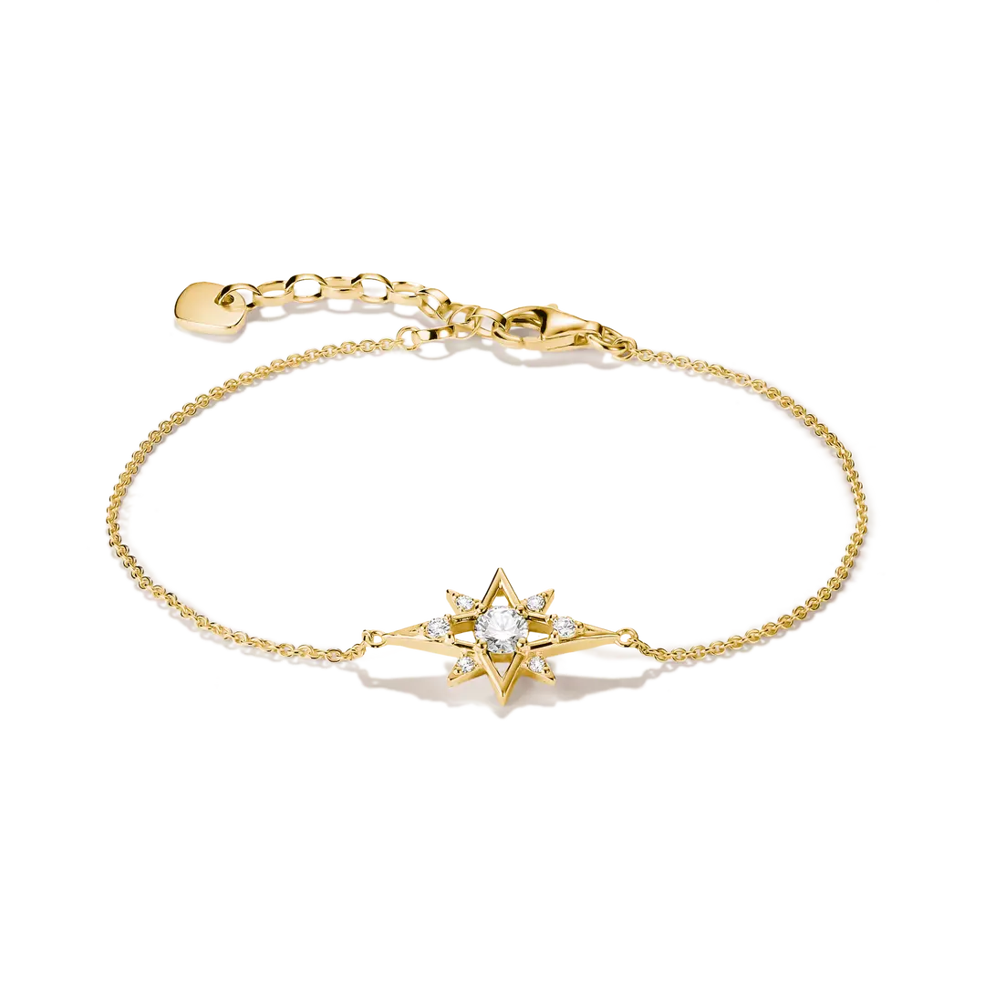 A delicate gold chain bracelet featuring a central starburst charm set with a clear round gemstone and small accent stones, displayed on a clean white background.