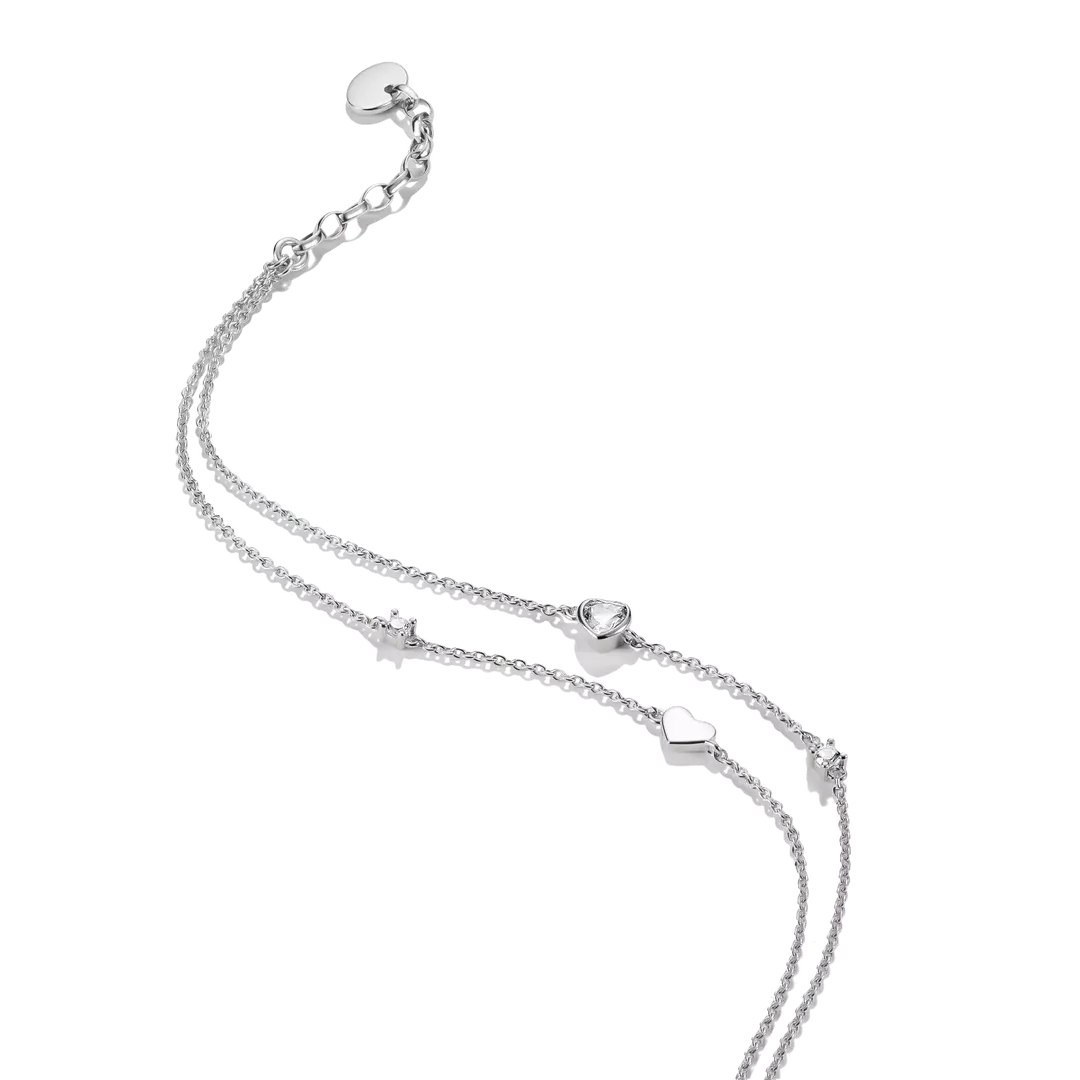 A delicate silver double-strand chain anklet featuring small heart charms, a heart-shaped bead, and an adjustable sliding clasp on a solid white background.