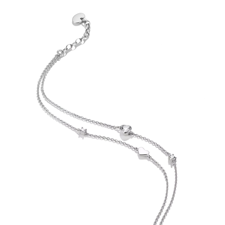 A delicate silver double-strand chain anklet featuring small heart charms, a heart-shaped bead, and an adjustable sliding clasp on a solid white background.