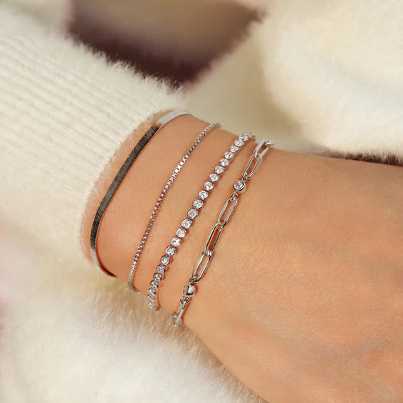 Close-up of a wrist wearing multiple bracelets on a soft background