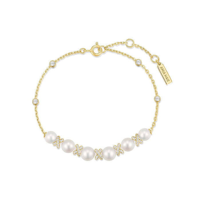 Gold bracelet with pearls and crystals on a white background