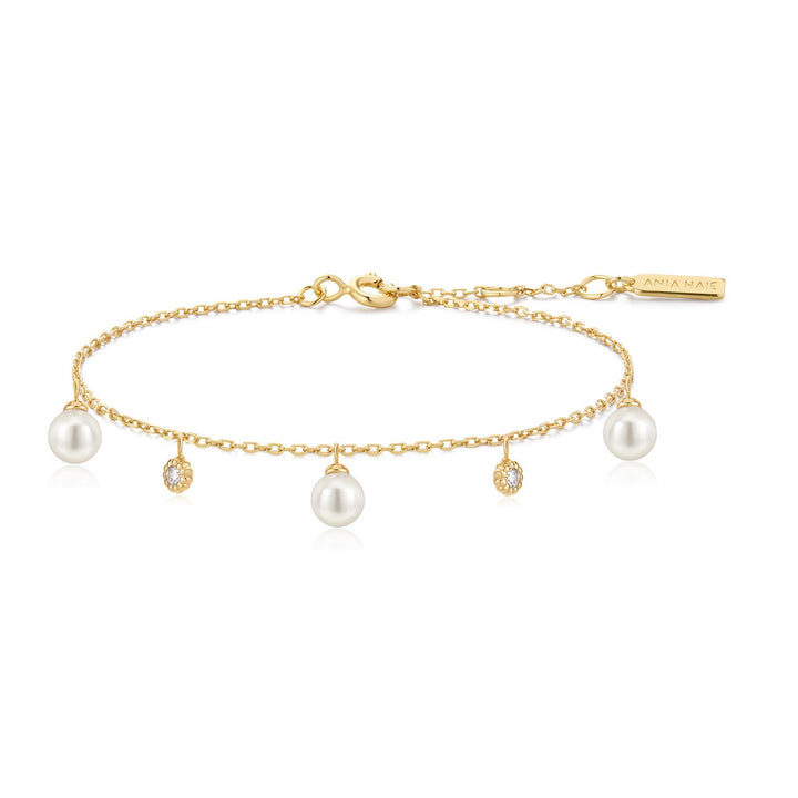 Gold bracelet with pearls and small diamonds on a white background