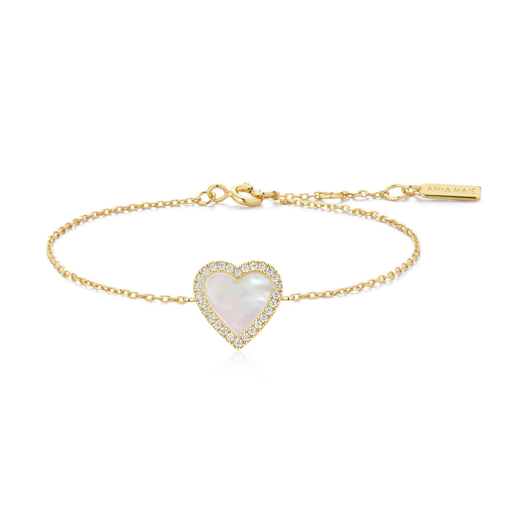 Gold bracelet with a heart-shaped pearl pendant on a white background