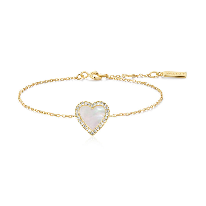 Gold bracelet with a heart-shaped pearl pendant on a white background