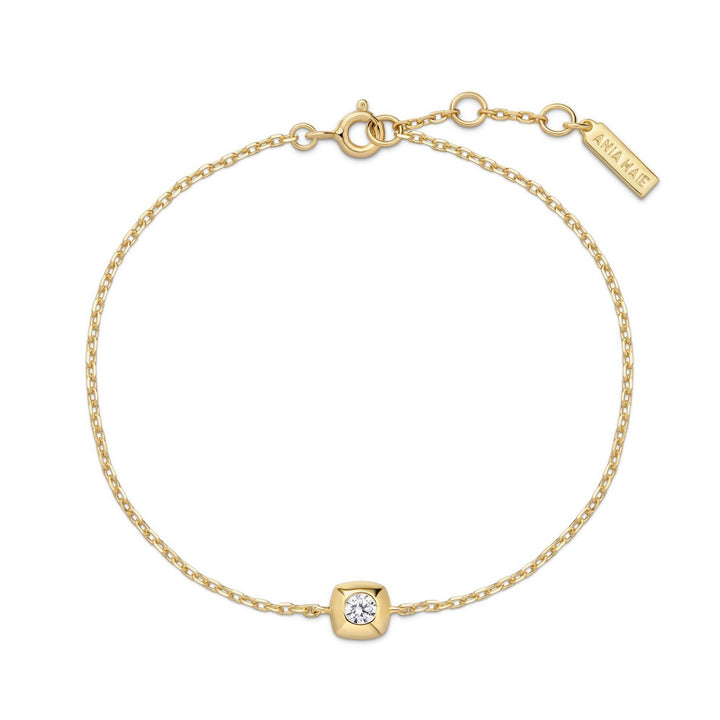 Gold bracelet with a diamond charm on a white background