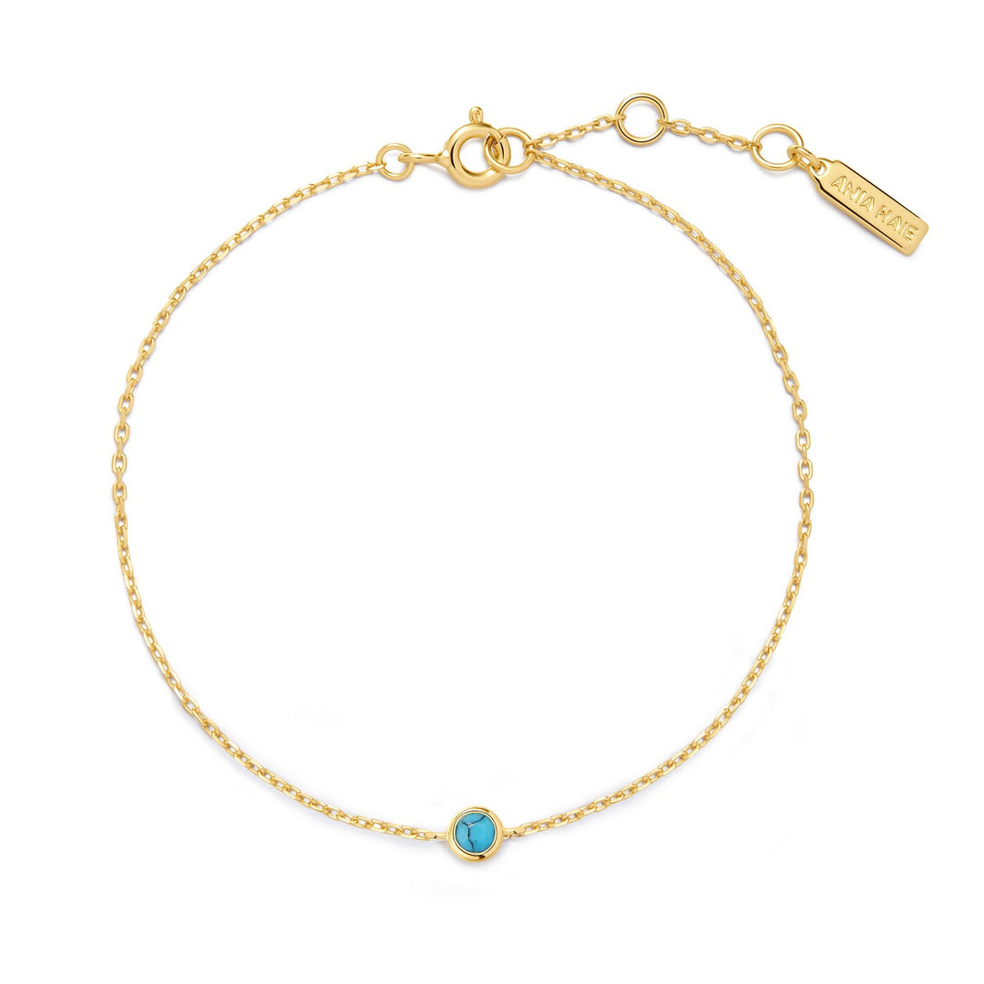 Gold bracelet with a turquoise stone on a white background