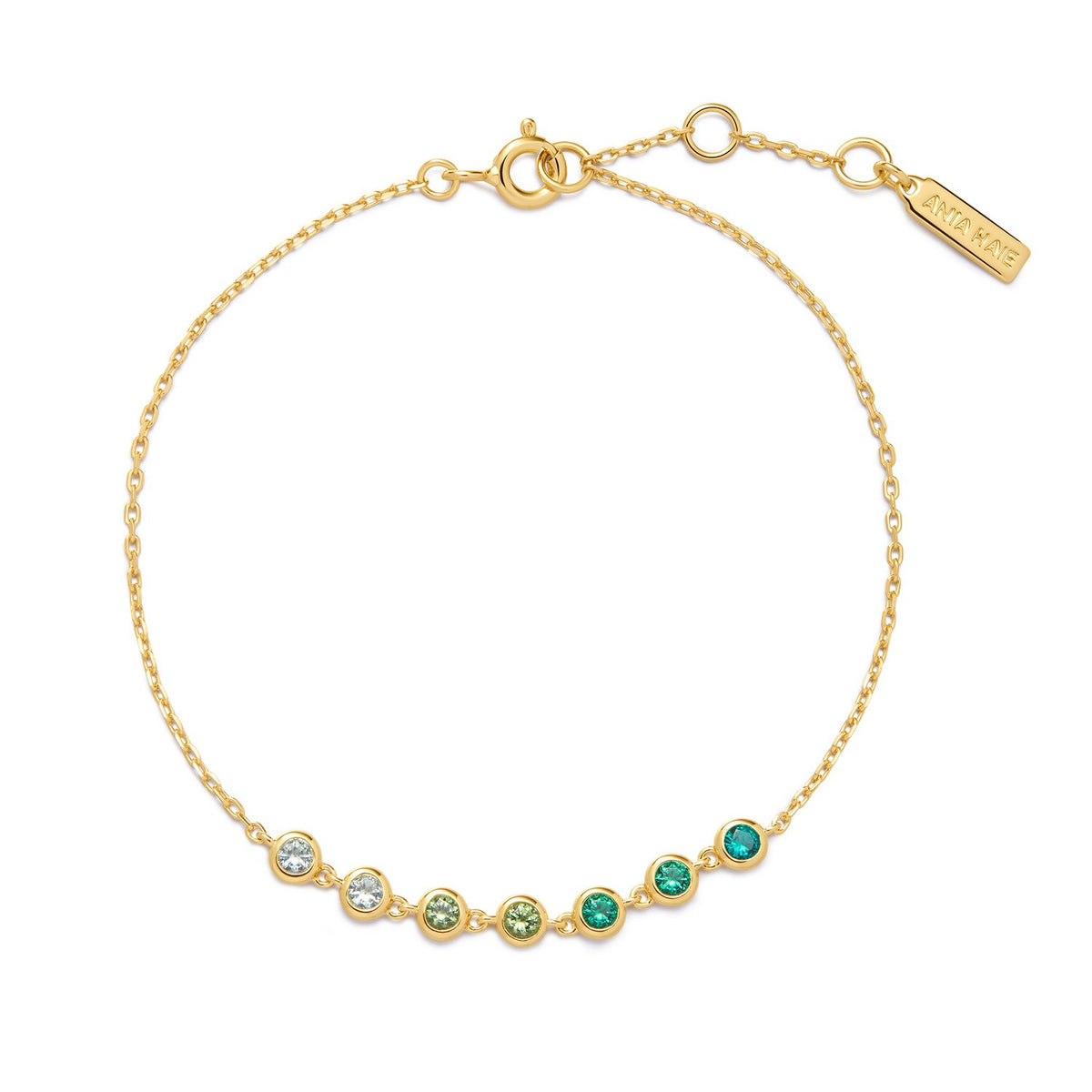 Gold bracelet with green and clear gemstones on a white background