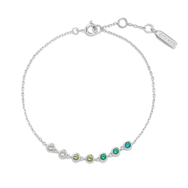 Silver bracelet with green gemstones on a white background