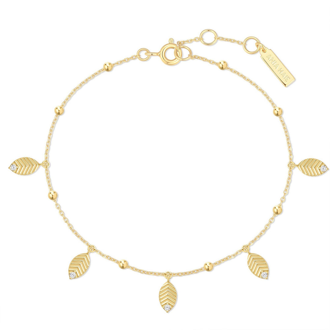 Gold bracelet with leaf-shaped charms on a white background