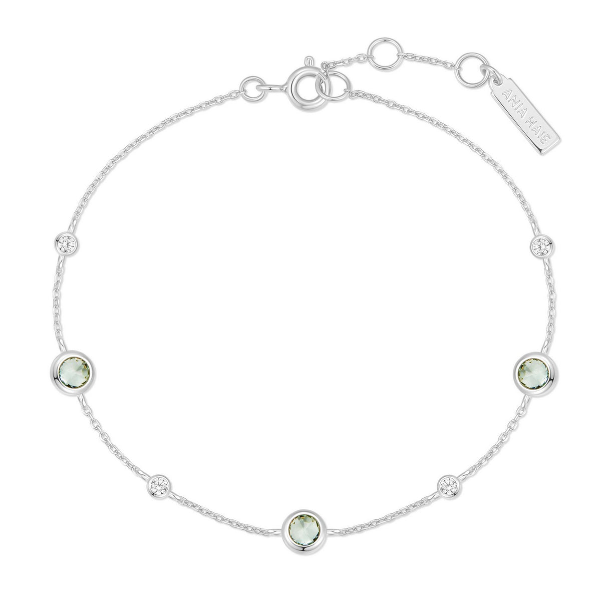 Silver bracelet with green gemstones on a white background