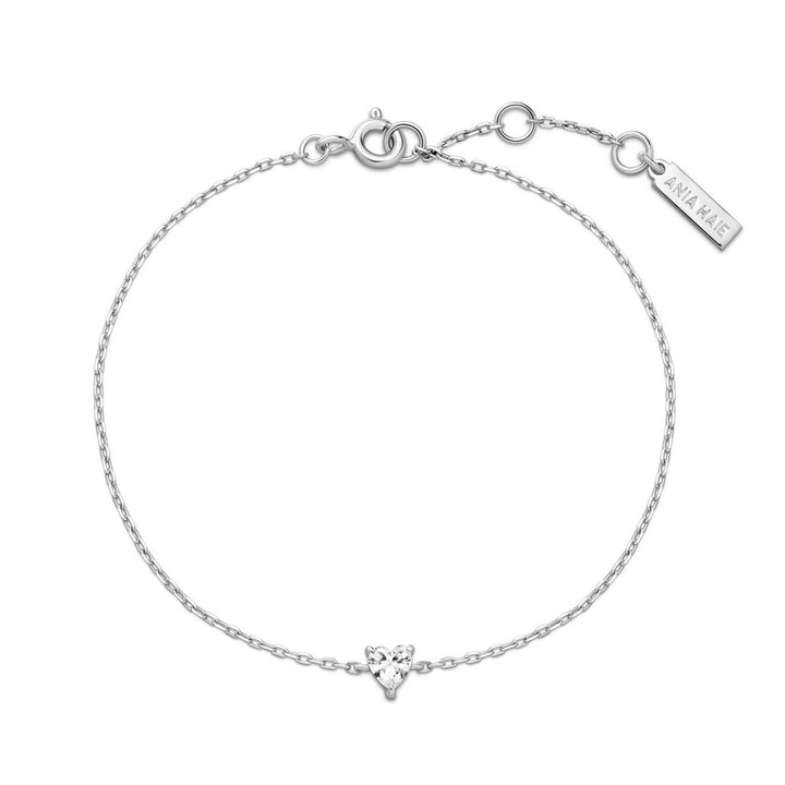 Silver bracelet with a small heart charm on a white background