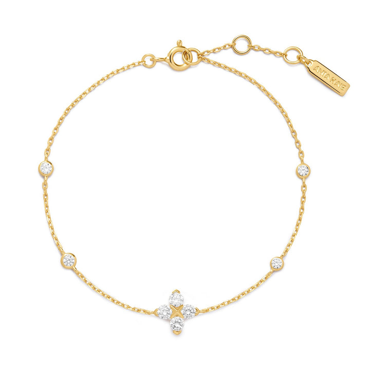 Gold bracelet with star-shaped clasp and diamond accents on a white background